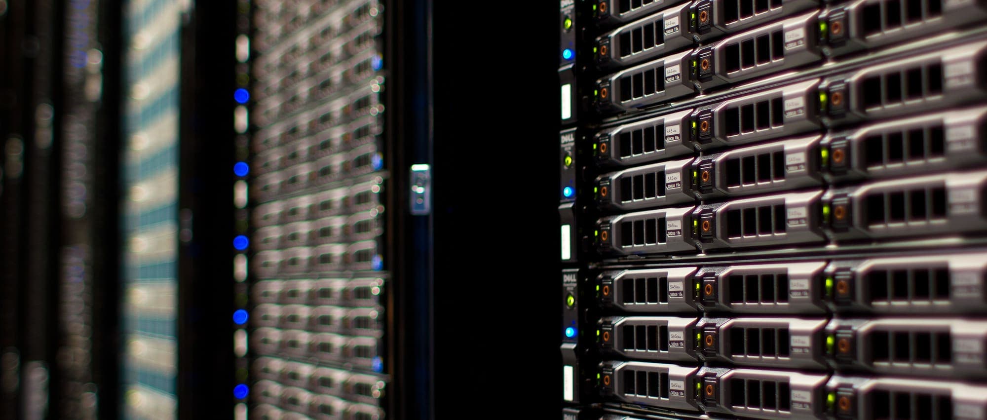 Primo piano di server in rack con dischi e luci di stato, in una sala server poco illuminata