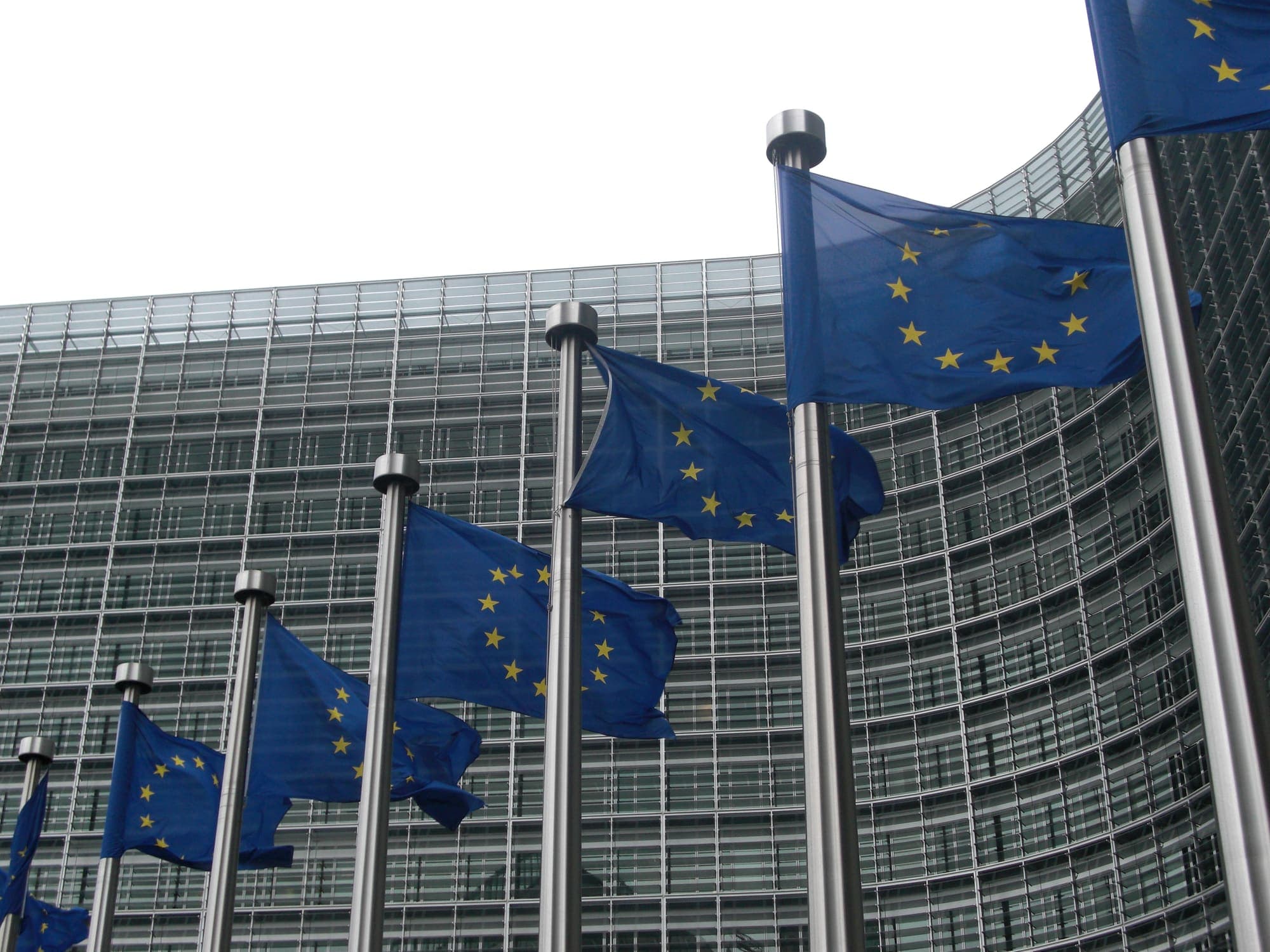 Bandiere dell'Unione europea davanti alla facciata in vetro del palazzo Berlaymont della Commissione europea a Bruxelles
